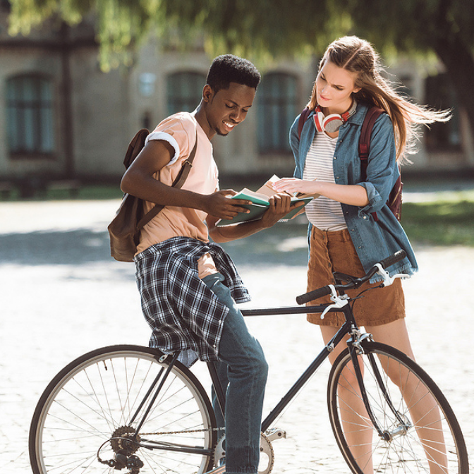 young college student on bike with female college student