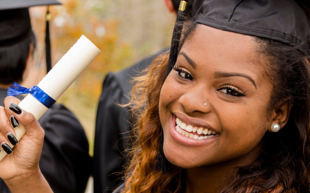 young woman smiling graduating and holding diploma